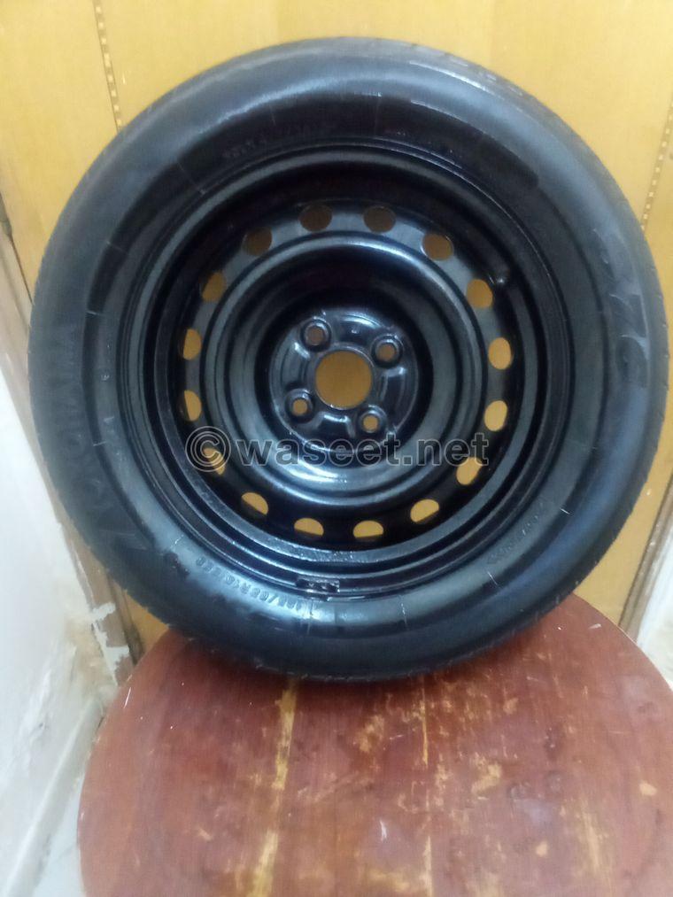 A tire with a rim for sale. The price is 50 dirhams  1