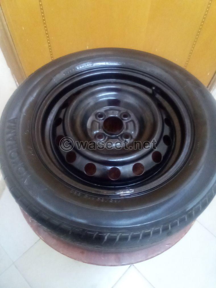 A tire with a rim for sale. The price is 50 dirhams  2